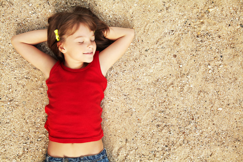 Niña en la arena de la playa el día de la Madre